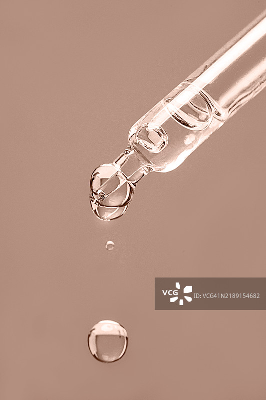 天然化妆品和美容产品液体，用于身体和面部护理的面部精华，玻璃滴管中的美容产品安瓶，带有滴落和阴影，米色棕色摩卡慕斯，2025年流行色。图片素材