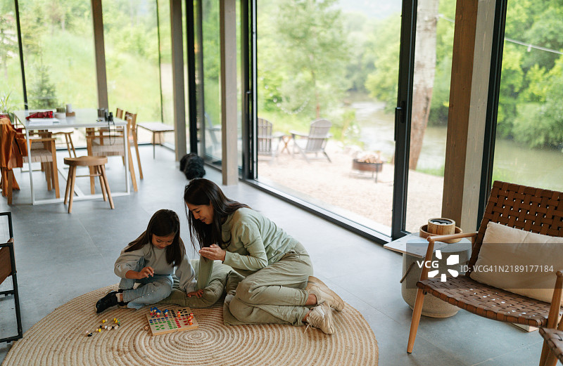 母女在温馨的现代家中玩桌游图片素材