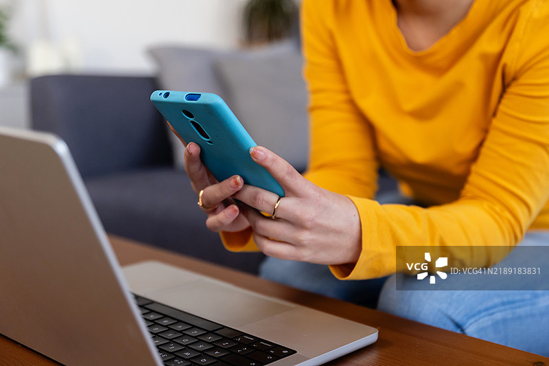 女性在家中使用智能手机和笔记本电脑图片素材