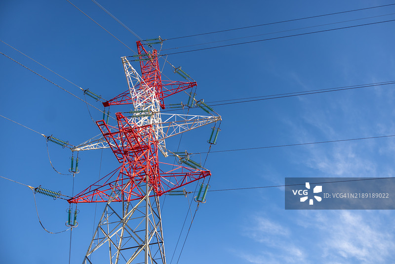 蓝天背景下的高压电线杆。图片素材