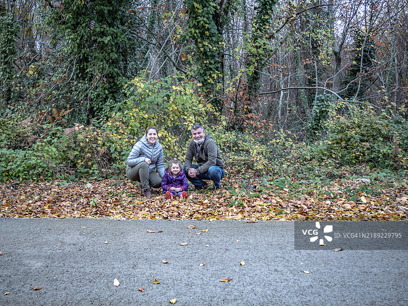 高角度视图的家庭坐在树木间的道路上图片素材