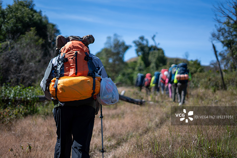 背包客在山间小径上徒步行走图片素材