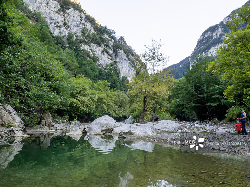 女人站在湖边，背靠着山脉图片素材