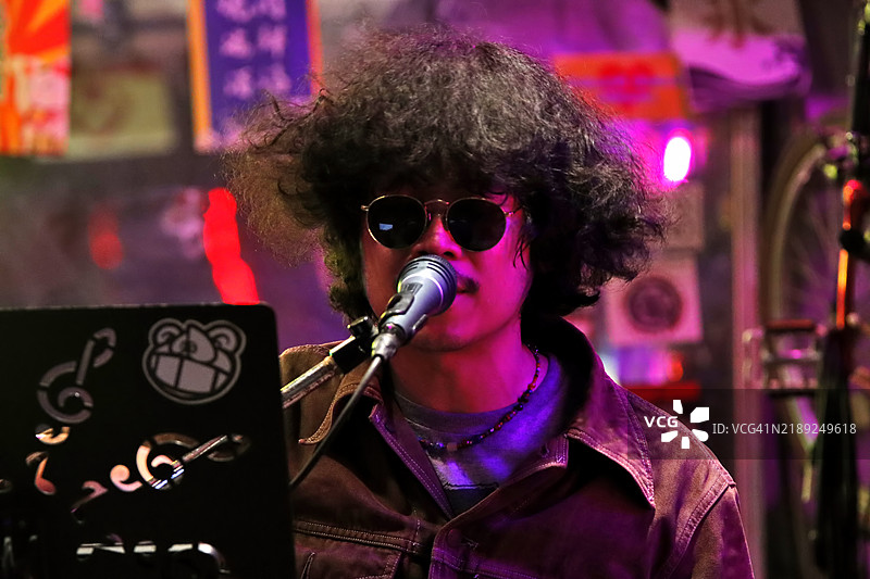 一名男子在排练或与乐队演出时对着麦克风唱歌的肖像。图片素材