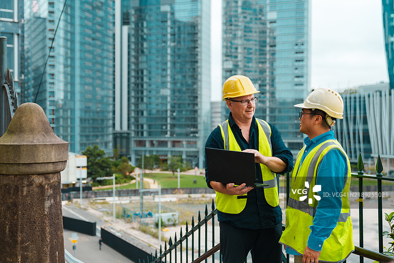 建筑工人在相互沟通时合作。图片素材