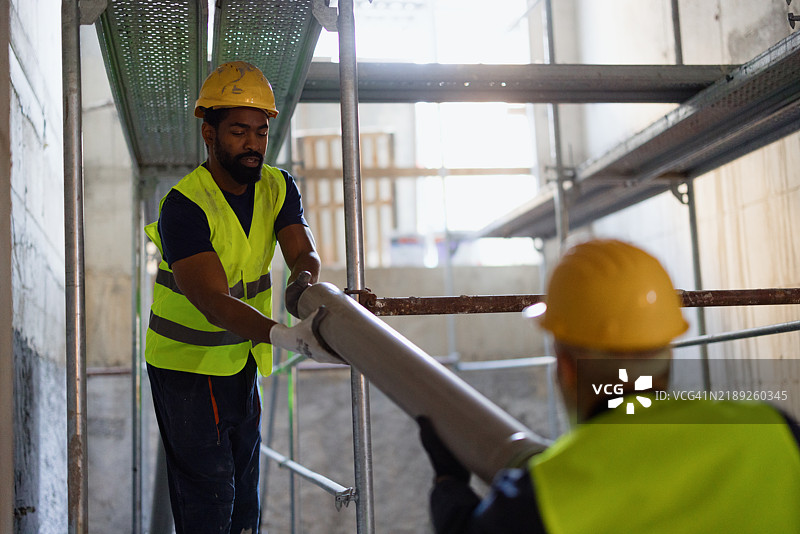建筑工人在室内合作进行建筑项目图片素材