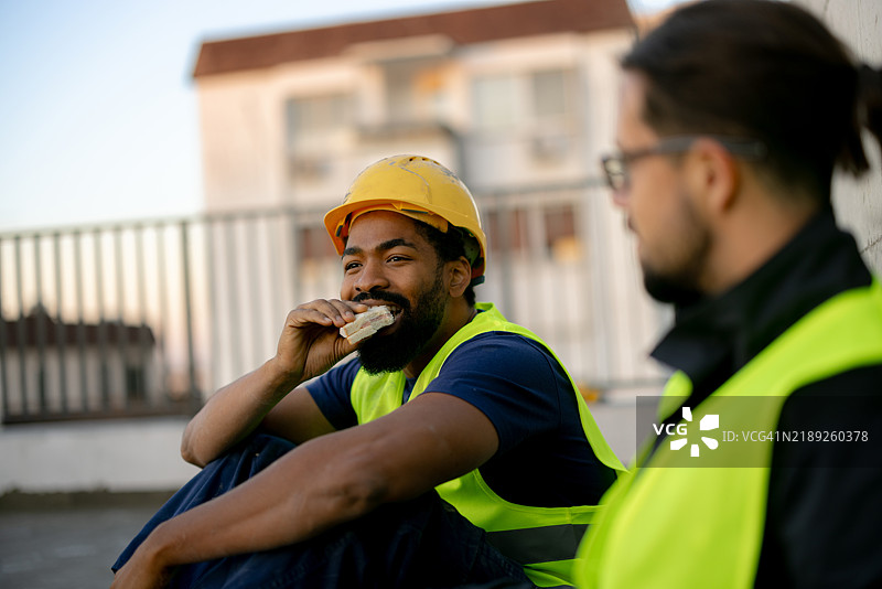 建筑工人在工地上休息吃午餐图片素材