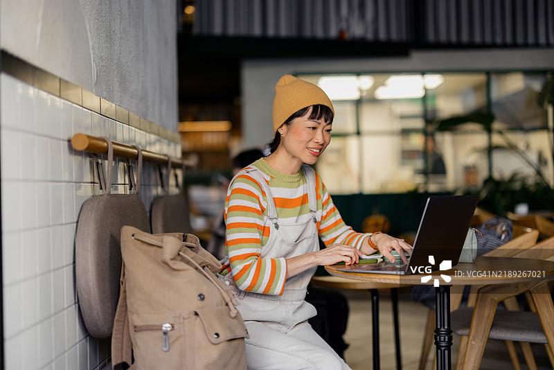 在舒适的咖啡店环境中使用笔记本电脑的女性图片素材
