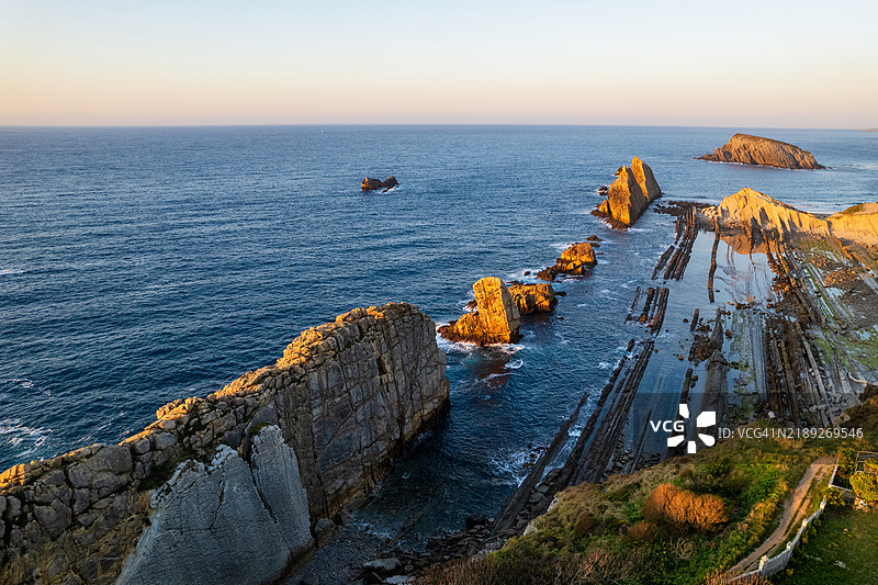 西班牙坎塔布里亚的阿尔尼亚海滩戏剧性的景观。阿斯图里亚斯的阿尔尼亚海滩日落时分。惊人的风景，线条，抽象形状，美丽的色彩。图片素材