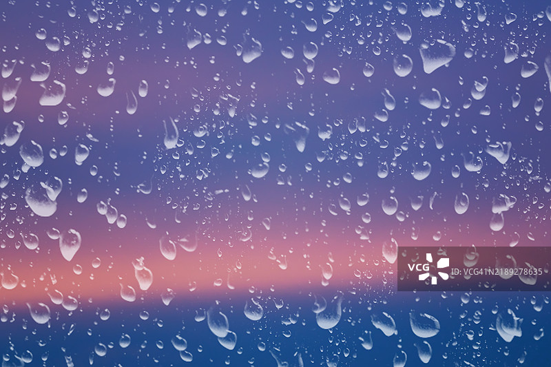 窗户上的雨滴与日落天空图片素材