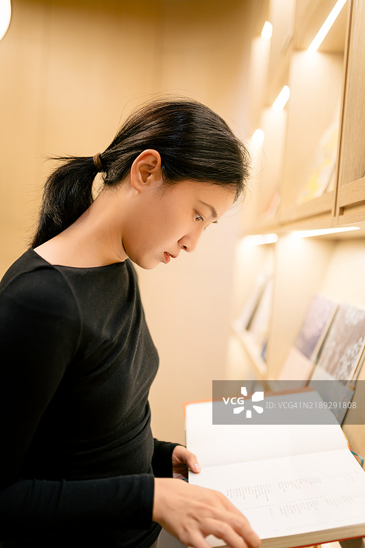 美丽的亚洲女性在书店购买书籍图片素材