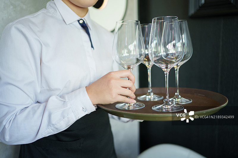 服务员手持红酒杯的特写镜头图片素材