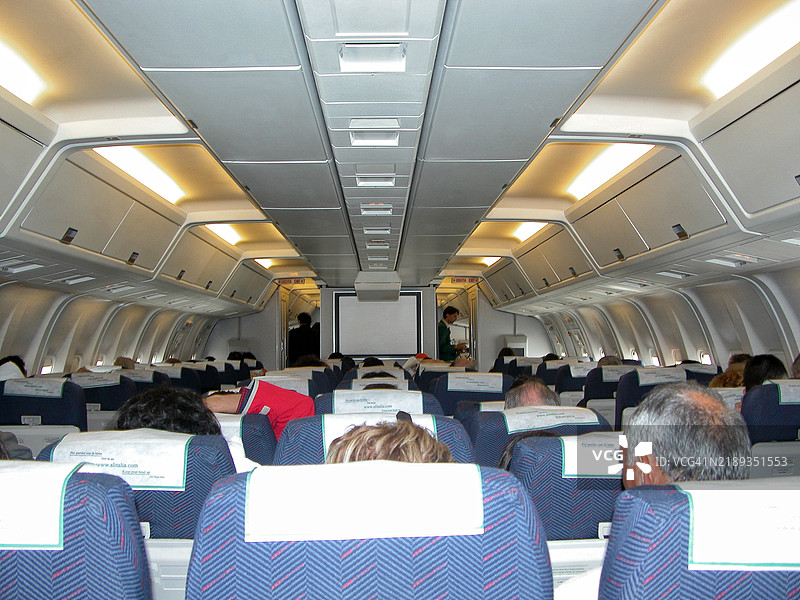 飞机内部，乘客坐在座位上图片素材