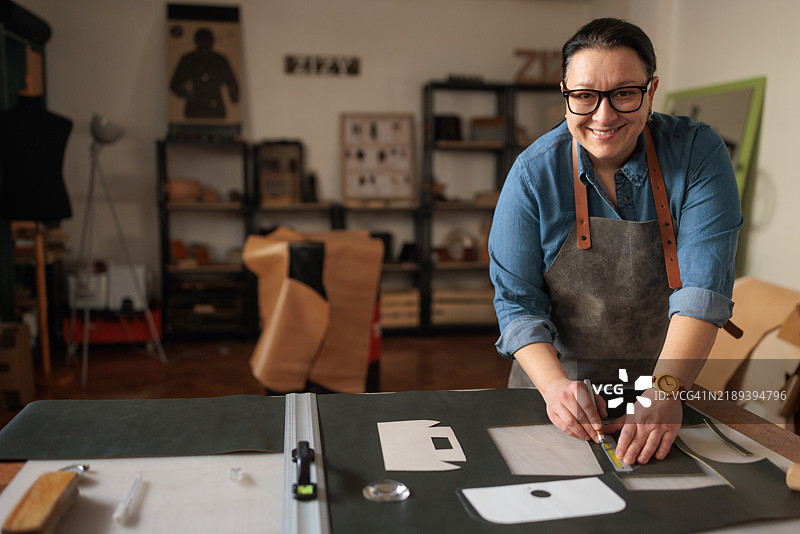 女工正在为定制设计裁剪皮革图片素材