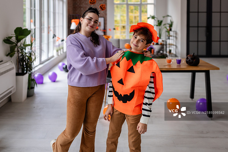 孩子穿着南瓜服装，微笑着调皮地摆姿势图片素材