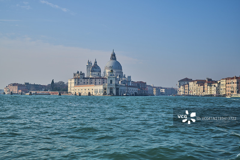 从水面上看威尼斯的“圣玛利亚·德拉·萨卢特大教堂”和“大运河”,冬日阳光明媚,意大利,欧洲图片素材