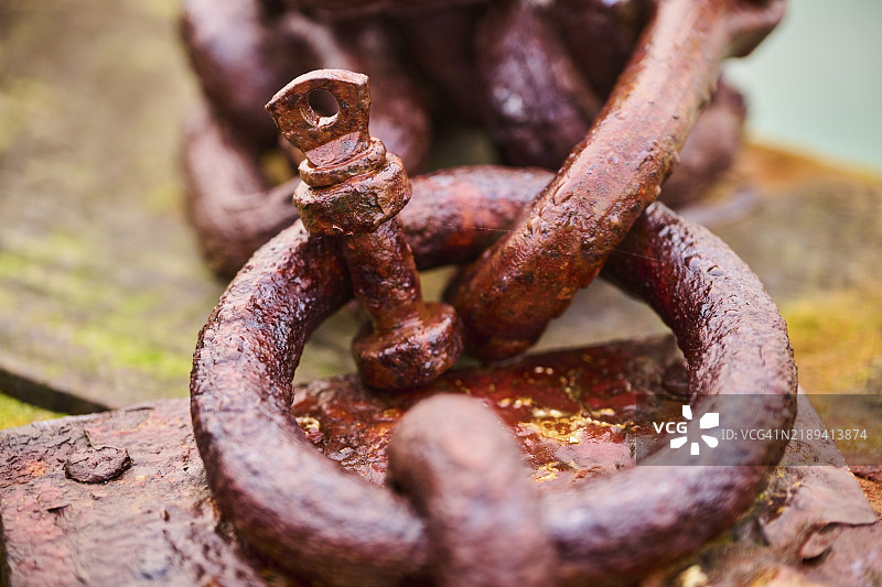冬季意大利威尼斯港口木头上的生锈旧链条，笼罩在雾气中。图片素材