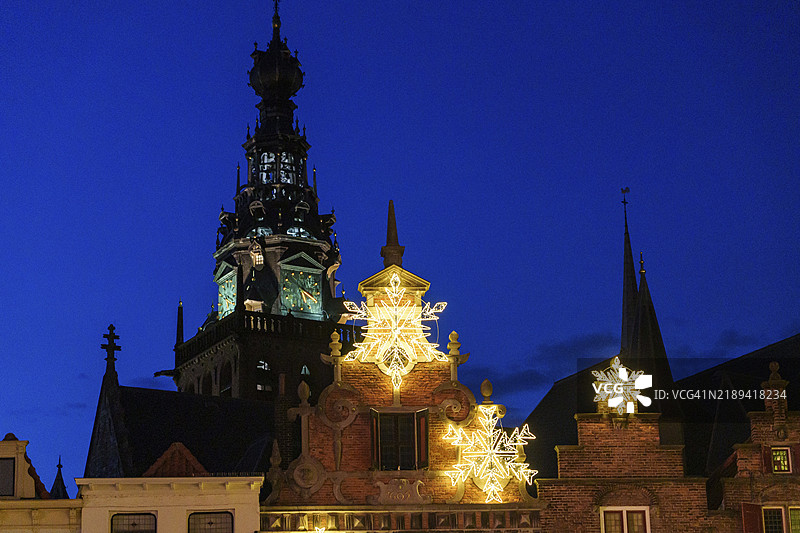 荷兰尼梅亨蓝色时刻的塔楼前，历史建筑装饰着圣诞灯光。图片素材
