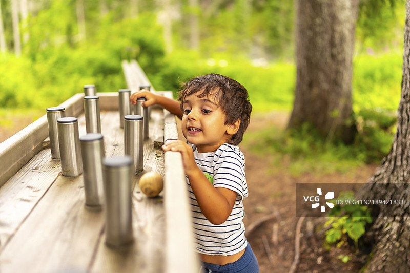 年轻孩子在自然公园的感官游乐区探索和互动，享受户外活动图片素材