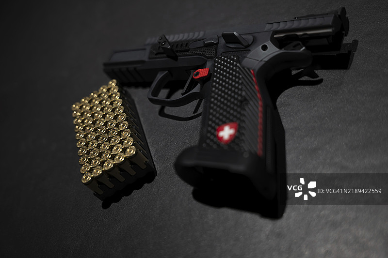 现代优雅的运动手枪，配有油门踏板和护裙，子弹置于灰色背景下，拍摄于瑞士图片素材