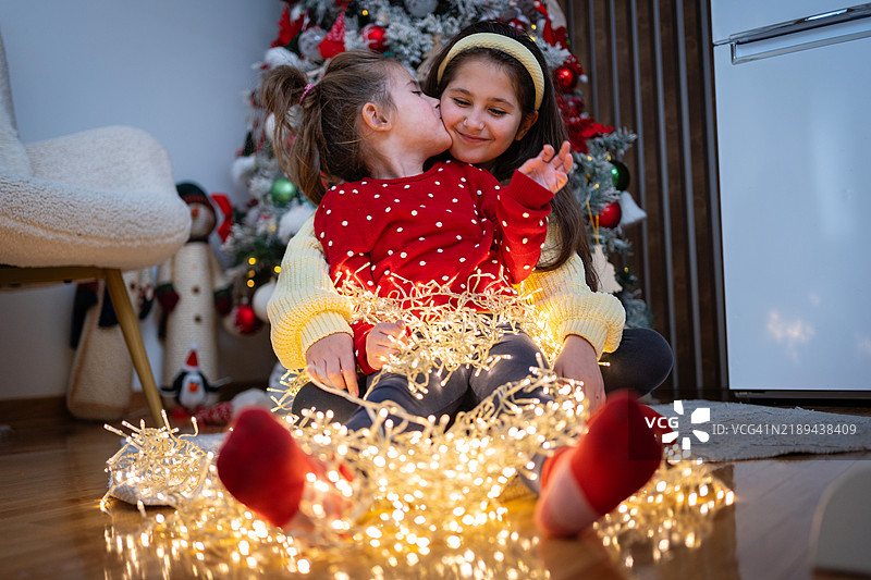 可爱的小女孩被节日灯饰包裹，感受圣诞的氛围图片素材