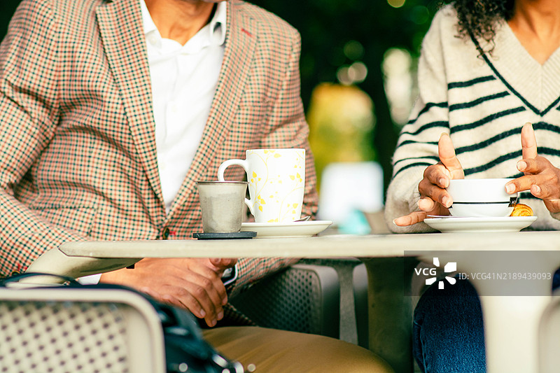 同事们在户外咖啡馆享受咖啡休息时间：促进联系与合作图片素材