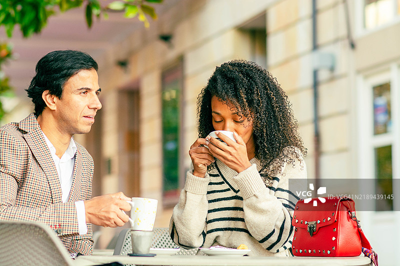 情侣在户外咖啡馆享受咖啡和交谈图片素材
