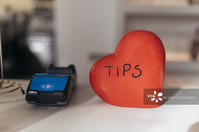 餐厅和酒吧服务台上的信用卡读卡器和心形小费箱特写图片素材