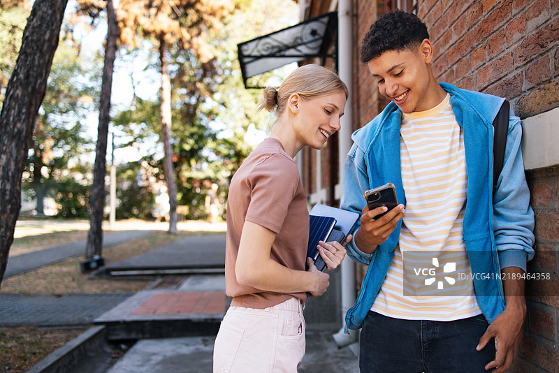 高中建筑外的青少年学生享受休息时光图片素材