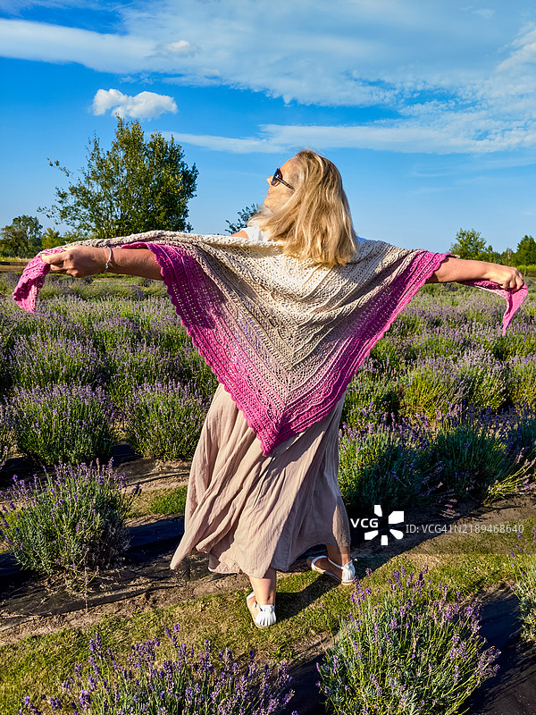 穿着彩色披肩的女人在薰衣草田中图片素材