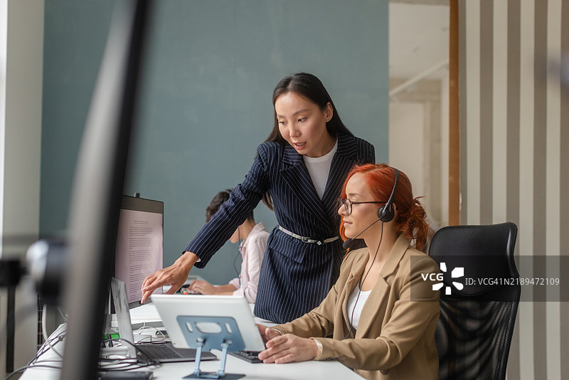 女商人在客户服务工作场所指导同事图片素材
