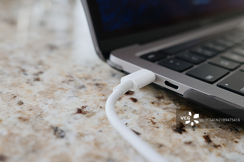 笔记本电脑在厨房台面上充电图片素材