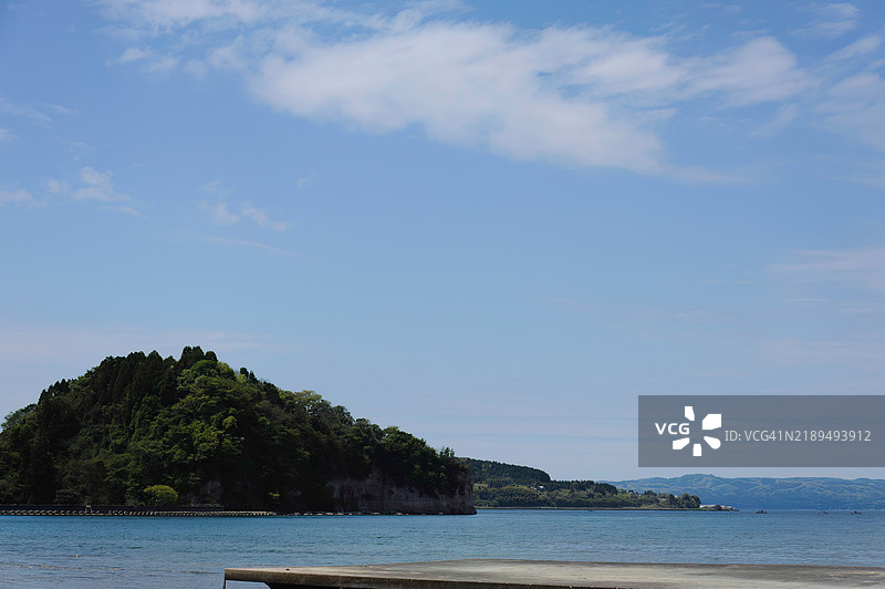 美丽的海滩在海豚游泳基地前。离岸有一块独特形状的岩石，称为军舰岛。图片素材