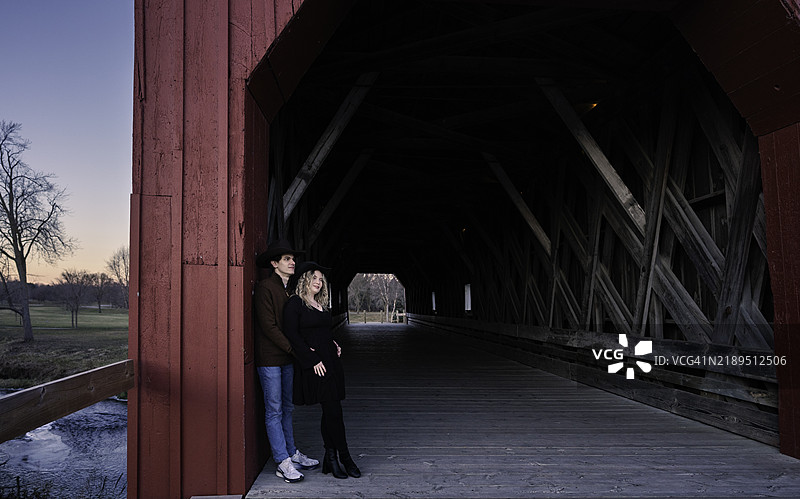 在明尼苏达州红翼市的老封闭桥上，冬日里一对二十多岁的恩爱情侣。图片素材