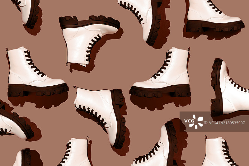 时尚潮流图案，由白色靴子鞋子构成，背景为米色棕色。2025年年度色“摩卡慕斯”的概念。图片素材