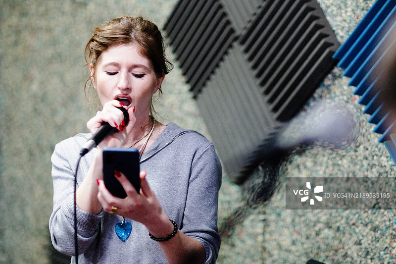 女人拿着麦克风唱歌图片素材