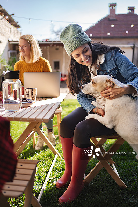 女人在后院工作时拥抱她的狗图片素材