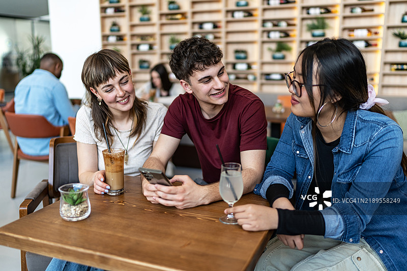 年轻朋友们在咖啡店里享受时光图片素材