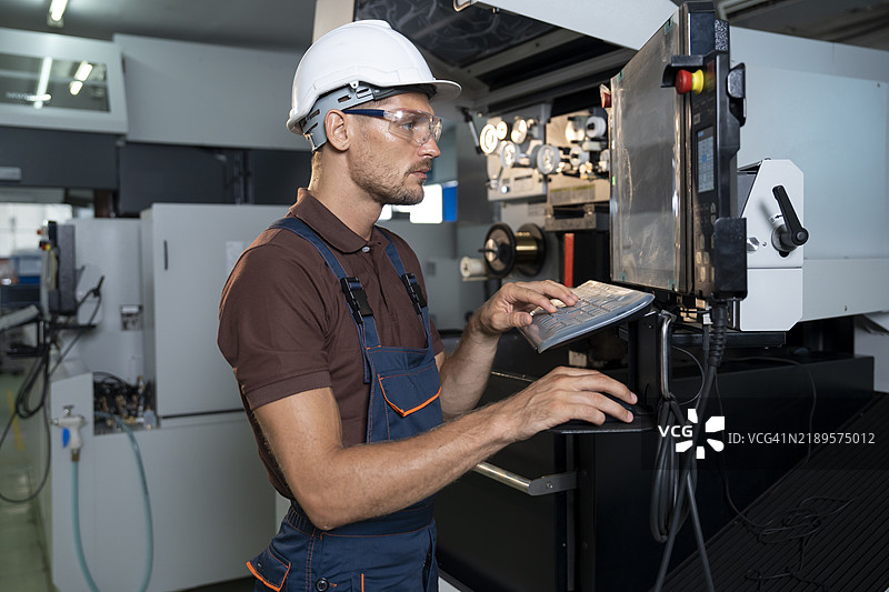 工人在进行零件质量控制时使用数控机床图片素材