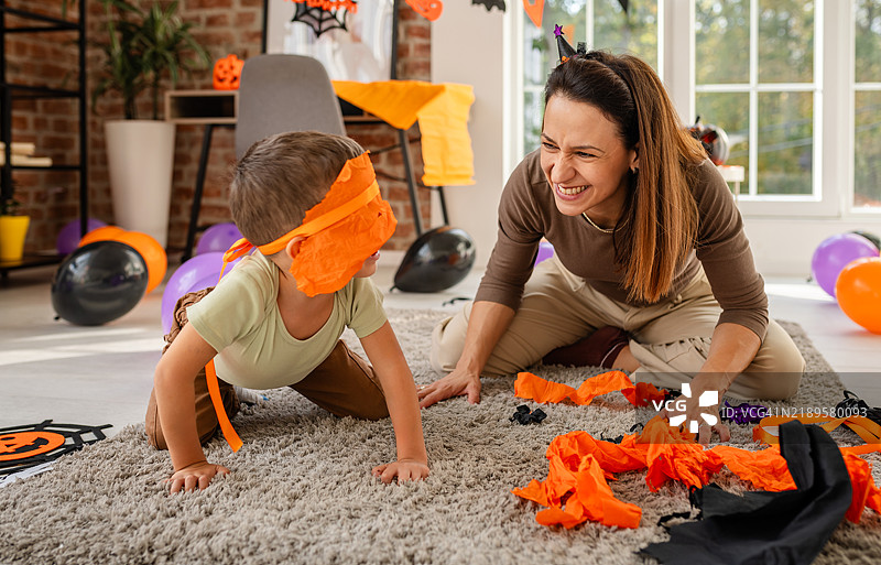 母亲和孩子在家一起享受万圣节活动和装饰图片素材