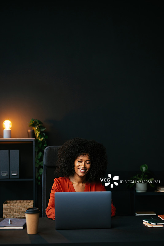 年轻女商人在现代办公室使用笔记本电脑工作图片素材