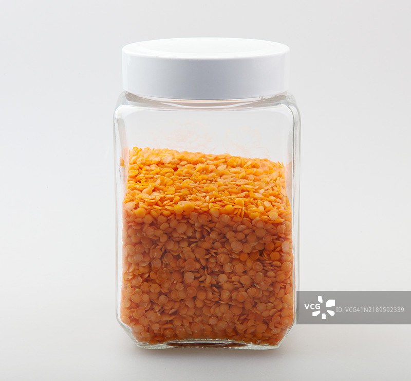白色背景下的厨房罐子里的红扁豆图片素材