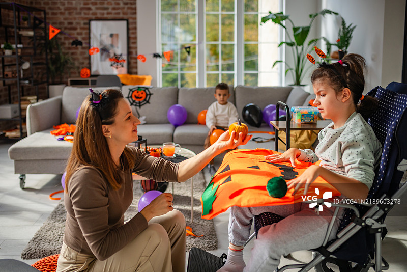 母亲在家与孩子们一起进行万圣节手工艺活动图片素材