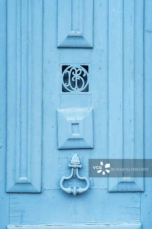 蓝色门上的华丽门环。图片素材