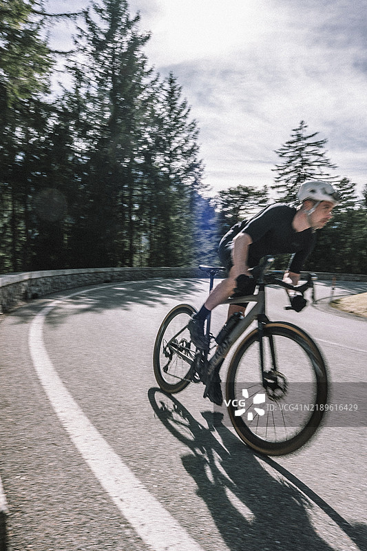 春季公路自行车骑行者在奥地利蒂罗尔的莱赫塔尔和坦海默谷之间，背景是阿尔卑斯山的迷人风景。图片素材