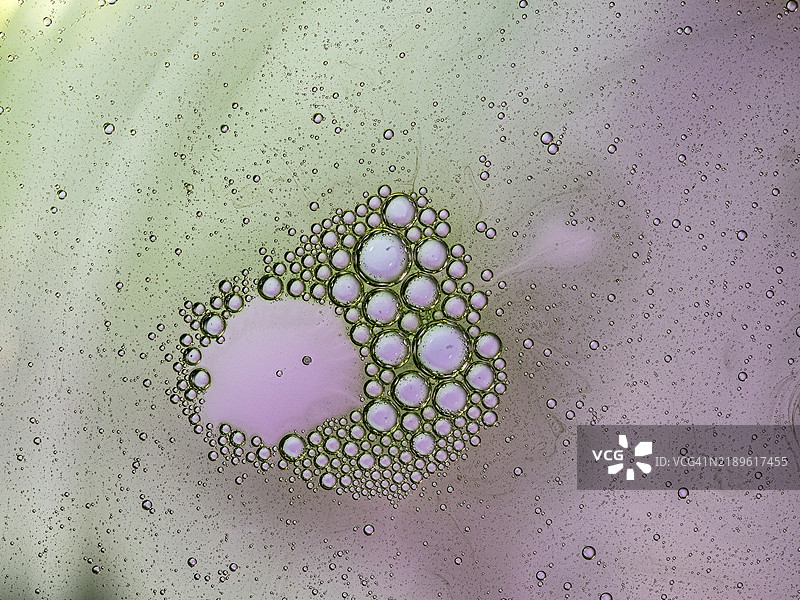 粉色和绿色的液体气泡形成分子结构。图片素材