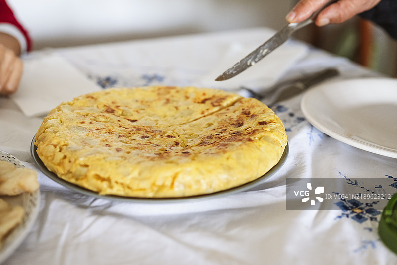 在桌子上端上西班牙土豆煎蛋饼图片素材