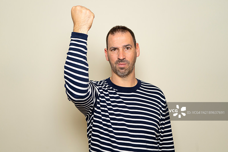 快乐而兴奋的有胡子的西班牙裔男子的工作室肖像图片素材