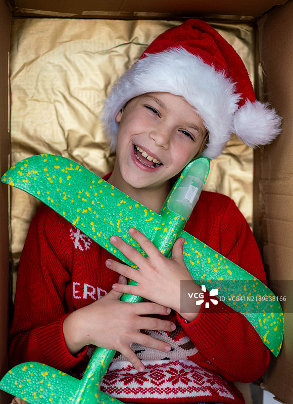 一个戴着帽子的男孩在新年礼盒里微笑的肖像图片素材