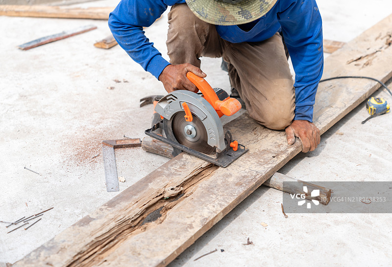 木匠正在使用圆锯切割木板。图片素材